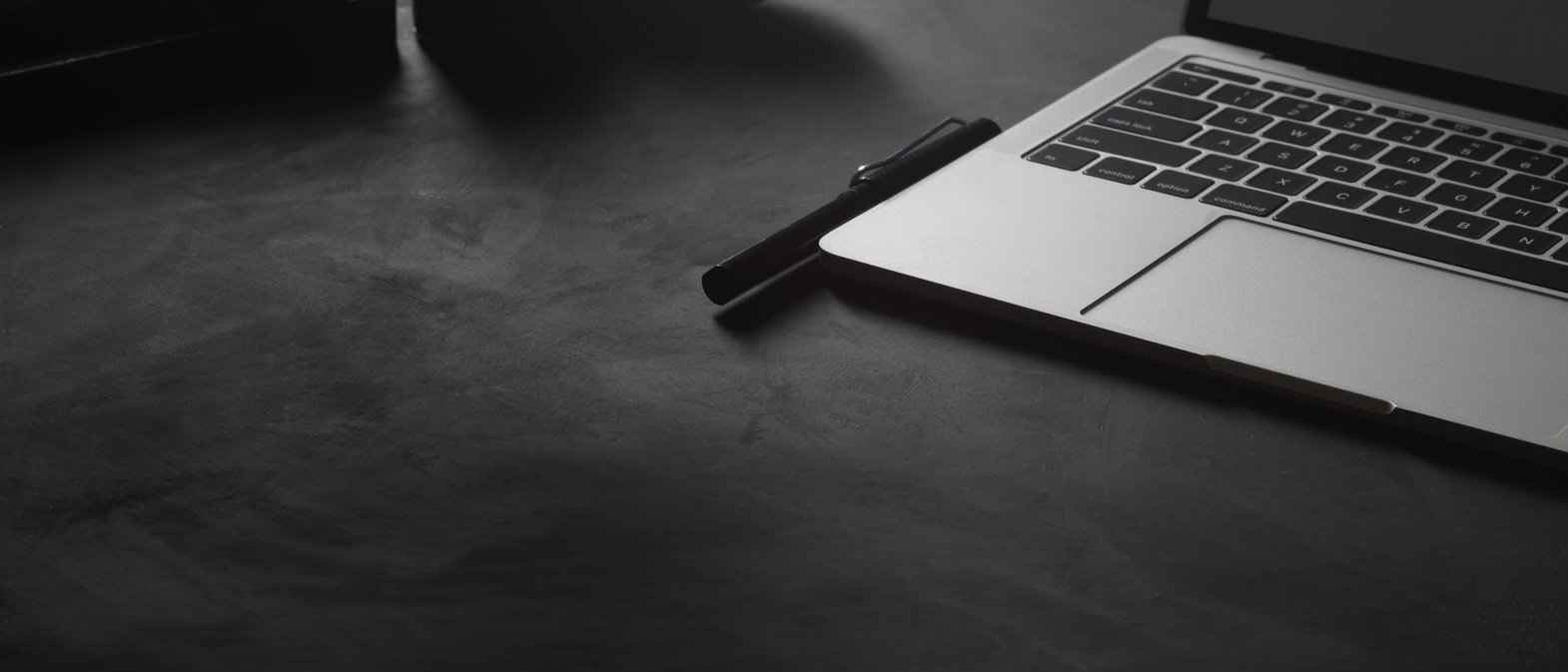 Black table with laptop, supplies and copy space